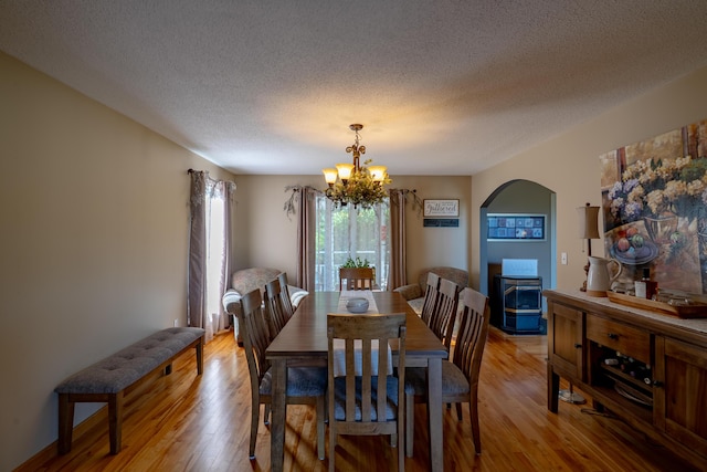 78 Lakeview Rd, Glenburn, ME 04401 - dining area with a chandelier, arched walkways, light wood-type flooring, and a textured ceiling