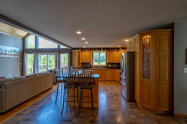 78 Lakeview Rd, Glenburn, ME 04401 - kitchen featuring open floor plan, freestanding refrigerator, recessed lighting, glass insert cabinets, and a kitchen breakfast bar