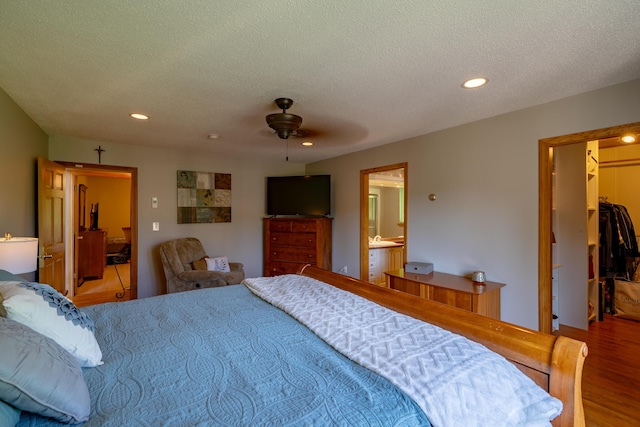 78 Lakeview Rd, Glenburn, ME 04401 - bedroom featuring wood finished floors, recessed lighting, a walk in closet, a textured ceiling, and ceiling fan