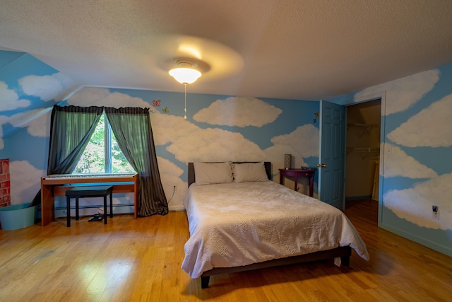 78 Lakeview Rd, Glenburn, ME 04401 - bedroom featuring wood finished floors, a textured ceiling, and vaulted ceiling