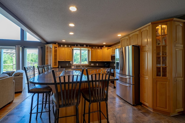 78 Lakeview Rd, Glenburn, ME 04401 - kitchen featuring a textured ceiling, stainless steel appliances, dark countertops, recessed lighting, and glass insert cabinets