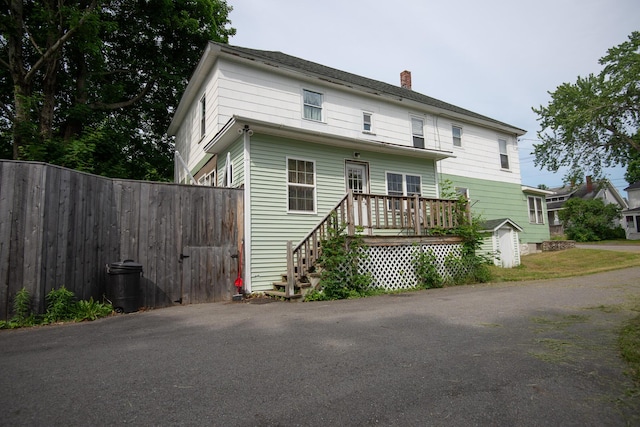 18/20 Beech St, East Millinocket, ME 04430 - rear view of house featuring a storage unit and a chimney
