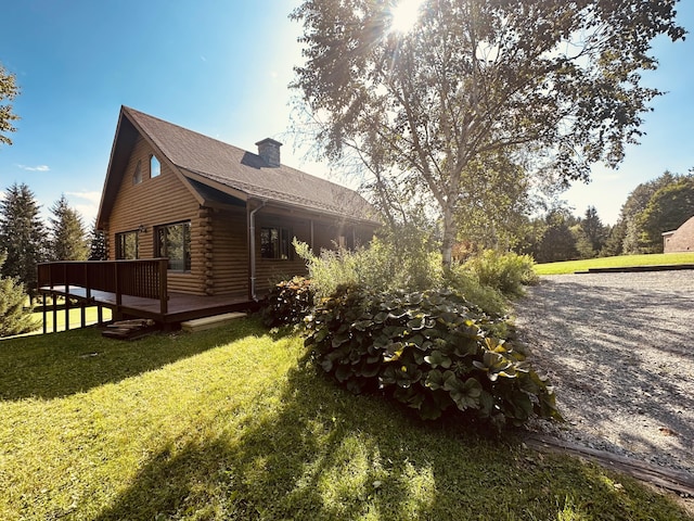 151 Schooland Rd, New Sweden, ME 04762 - view of home's exterior featuring a chimney, log siding, a deck, and a lawn