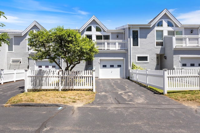 36 Ocean House Way Unit E4, York, ME 03909 - townhome / multi-family property featuring asphalt driveway, a garage, a balcony, and a fenced front yard