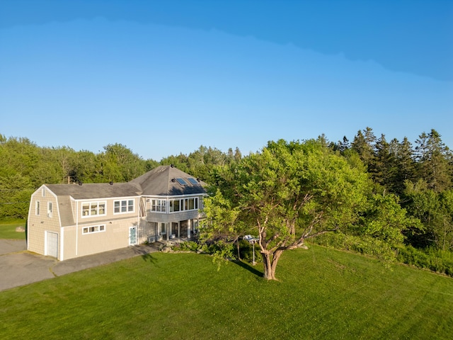 48 Sheltons Rd, Trenton, ME 04605 - view of front of house with a front lawn, a gambrel roof, a balcony, a garage, and solar panels