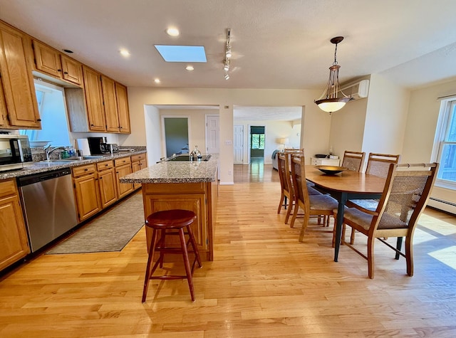 48 Sheltons Rd, Trenton, ME 04605 - kitchen featuring appliances with stainless steel finishes, light wood-style flooring, a kitchen bar, brown cabinetry, and a skylight