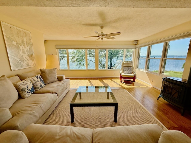 48 Sheltons Rd, Trenton, ME 04605 - living room with a wood stove, a water view, wood finished floors, and a ceiling fan