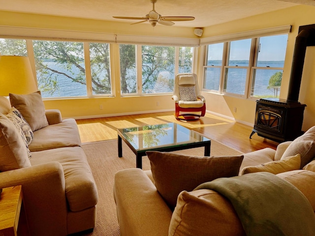48 Sheltons Rd, Trenton, ME 04605 - living room with a wood stove, a water view, wood finished floors, and healthy amount of natural light