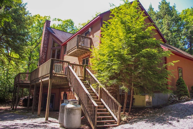 42 Knowles Point Rd, Bridgton, ME 04009 - back of house with a balcony, stairs, a chimney, and a wooden deck