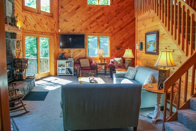 42 Knowles Point Rd, Bridgton, ME 04009 - carpeted living area featuring plenty of natural light, a high ceiling, stairway, wood walls, and a baseboard radiator