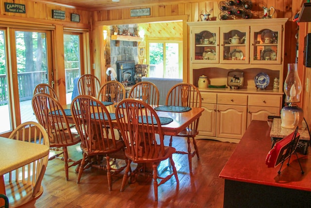 42 Knowles Point Rd, Bridgton, ME 04009 - dining area featuring wooden walls, a wood stove, and dark wood-type flooring