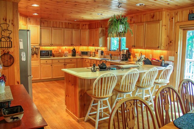 42 Knowles Point Rd, Bridgton, ME 04009 - kitchen with freestanding refrigerator, light countertops, wooden ceiling, a peninsula, and wooden walls