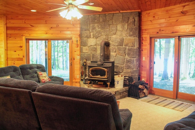 42 Knowles Point Rd, Bridgton, ME 04009 - living area featuring a wood stove, wood ceiling, wood walls, healthy amount of natural light, and ceiling fan