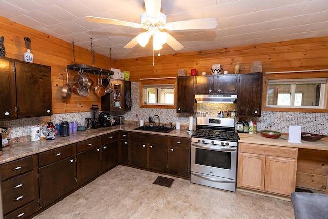 143 Mayfield Rd, Moscow, ME 04920 - kitchen featuring gas stove, under cabinet range hood, a ceiling fan, wood walls, and backsplash