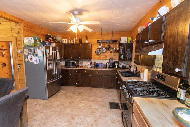 143 Mayfield Rd, Moscow, ME 04920 - kitchen with appliances with stainless steel finishes, wood walls, butcher block counters, dark brown cabinets, and ceiling fan