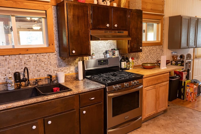 143 Mayfield Rd, Moscow, ME 04920 - kitchen with stainless steel gas range, under cabinet range hood, backsplash, and dark brown cabinetry
