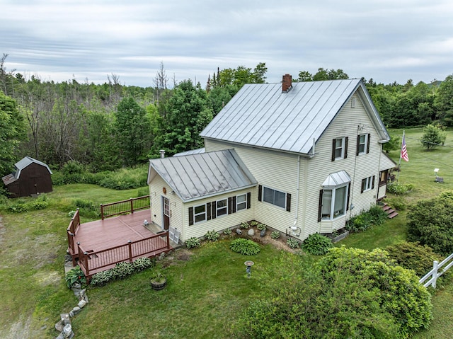 143 Mayfield Rd, Moscow, ME 04920 - view of side of home with a chimney, a standing seam roof, a metal roof, a storage unit, and a lawn