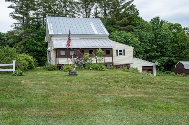 143 Mayfield Rd, Moscow, ME 04920 - view of front of home with a front yard, a standing seam roof, a metal roof, a garage, and an outbuilding