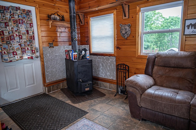143 Mayfield Rd, Moscow, ME 04920 - sitting room featuring a wood stove, wooden walls, and stone finish flooring