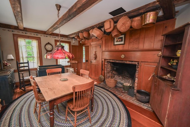 337 Copeland Hill Rd, Holden, ME 04429 - dining space featuring wood finished floors, beam ceiling, and a fireplace