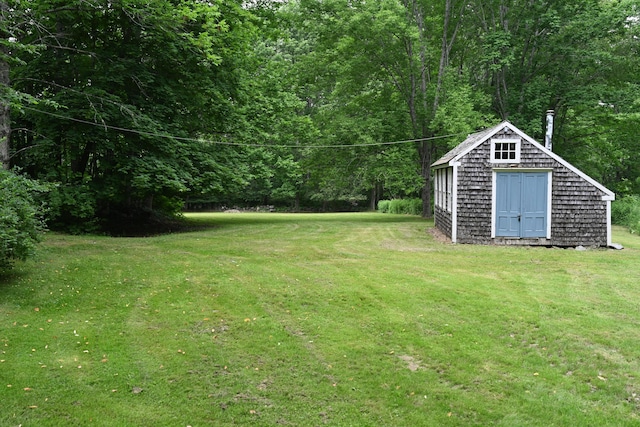 337 Copeland Hill Rd, Holden, ME 04429 - view of grassy yard featuring a storage unit and a wooded view