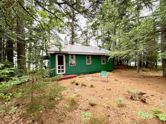 PE021 01 Unit T1 R8, Wels, ME 04462 - view of front of house with a chimney, a metal roof, and an outdoor structure