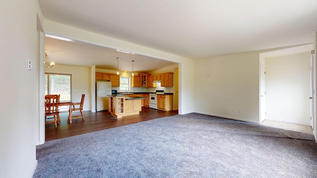 452 Flat Rd, Bethel, ME 04217 - unfurnished living room featuring dark colored carpet and a chandelier