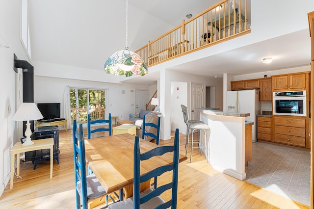 61 Dwelly Point Rd, Franklin, ME 04634 - dining room featuring high vaulted ceiling, stairs, and light wood finished floors