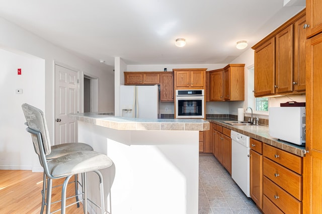 61 Dwelly Point Rd, Franklin, ME 04634 - kitchen with white appliances, brown cabinetry, a center island, and a breakfast bar