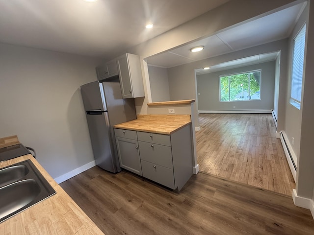 69 Heath St, Oakland, ME 04963 - kitchen featuring freestanding refrigerator, a baseboard heating unit, gray cabinets, wooden counters, and dark wood-style floors