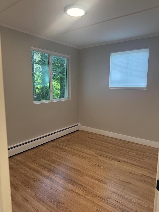69 Heath St, Oakland, ME 04963 - spare room featuring a baseboard heating unit, ornamental molding, and light wood finished floors