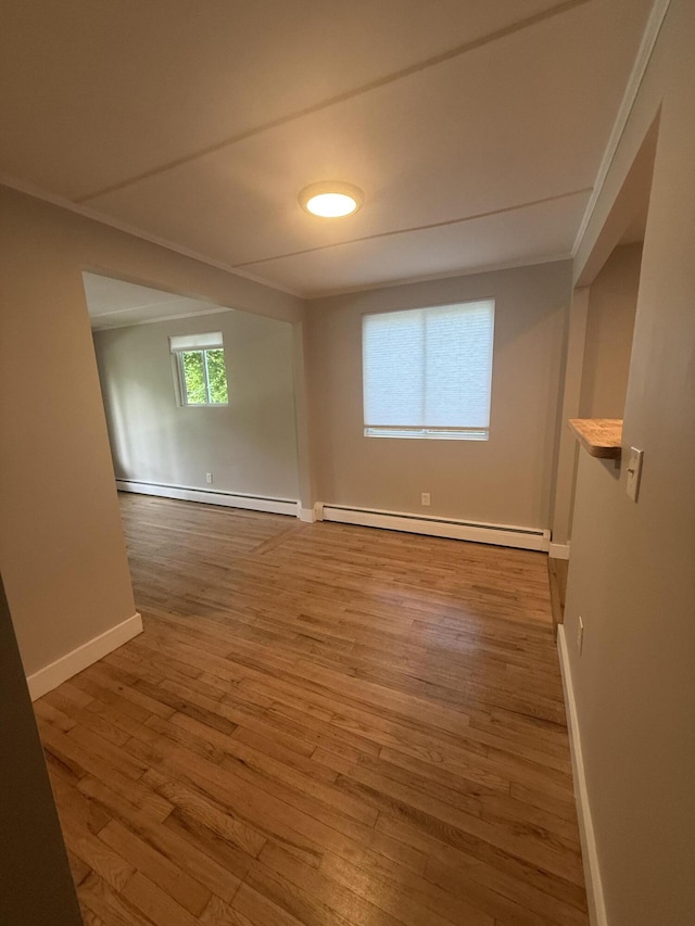 69 Heath St, Oakland, ME 04963 - empty room featuring baseboard heating, wood finished floors, and ornamental molding