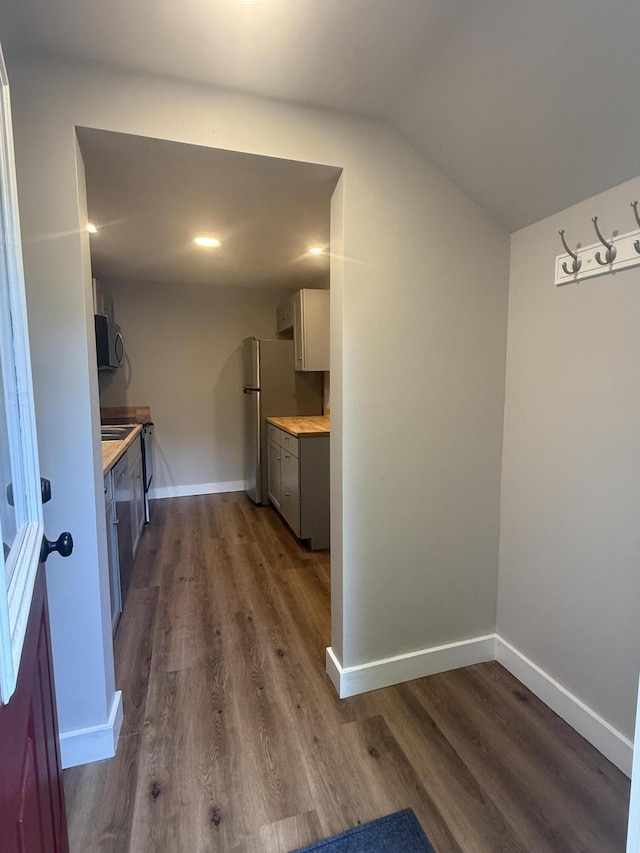 69 Heath St, Oakland, ME 04963 - kitchen with light countertops, dark wood-style floors, vaulted ceiling, and freestanding refrigerator