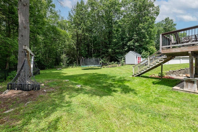 13 Dobson Rd, Berwick, ME 03901 - view of green lawn with a trampoline, stairs, a wooden deck, and a storage unit