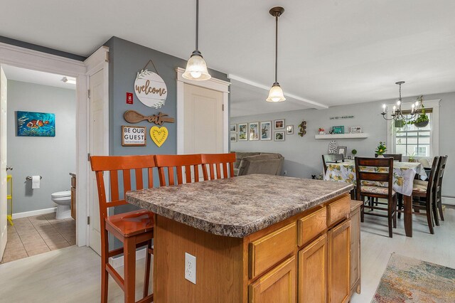 13 Dobson Rd, Berwick, ME 03901 - kitchen with a center island, a chandelier, pendant lighting, and brown cabinetry