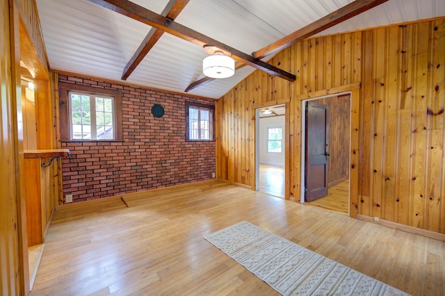 61 Shore Rd, Sebago, ME 04029 - empty room with wooden walls, light wood-type flooring, brick wall, and plenty of natural light