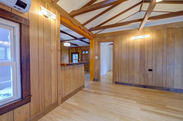 61 Shore Rd, Sebago, ME 04029 - unfurnished room with a wall mounted AC, wooden walls, and light wood-style flooring