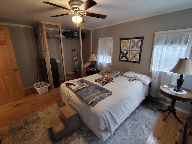 114 E Shore Rd, Benedicta Twp, ME 04733 - bedroom featuring wood finished floors, a closet, crown molding, and a ceiling fan