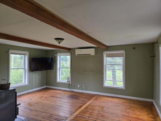 471 Chandler Hill Rd, Ripley, ME 04930 - unfurnished living room featuring a wall mounted AC, beamed ceiling, and hardwood / wood-style flooring