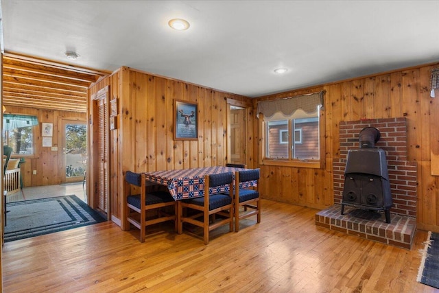 48 Green Bay Rd, Newfield, ME 04095 - dining room featuring wood walls, a wood stove, and hardwood / wood-style flooring