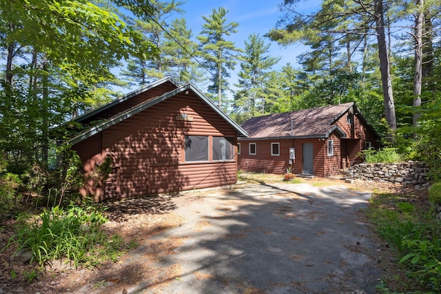 48 Green Bay Rd, Newfield, ME 04095 - view of property exterior with faux log siding, an outbuilding, and driveway