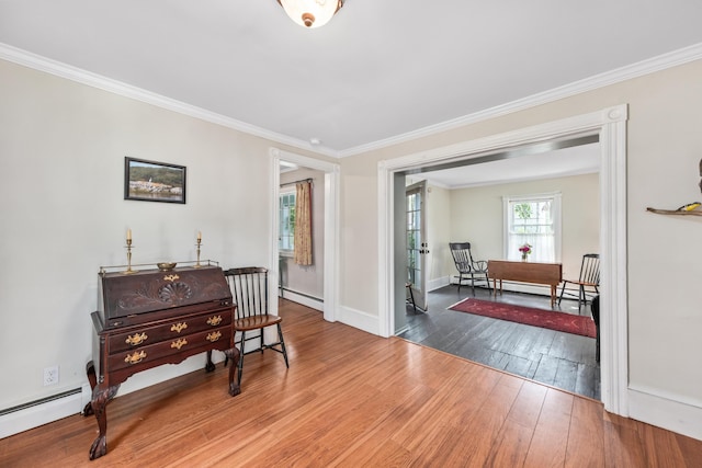5 Purchase St, Rockland, ME 04841 - living area featuring a baseboard heating unit, ornamental molding, and wood finished floors