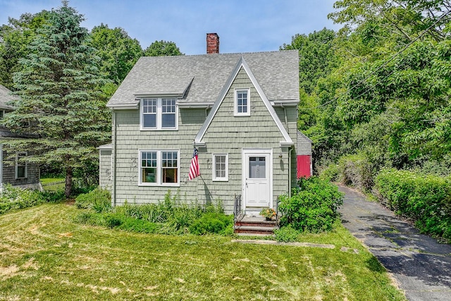 69 W Meadow Rd, Rockland, ME 04841 - view of front of property featuring a shingled roof, a front yard, and a chimney