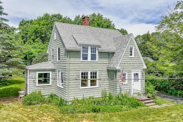 69 W Meadow Rd, Rockland, ME 04841 - view of front of house with a shingled roof, a chimney, and a front lawn