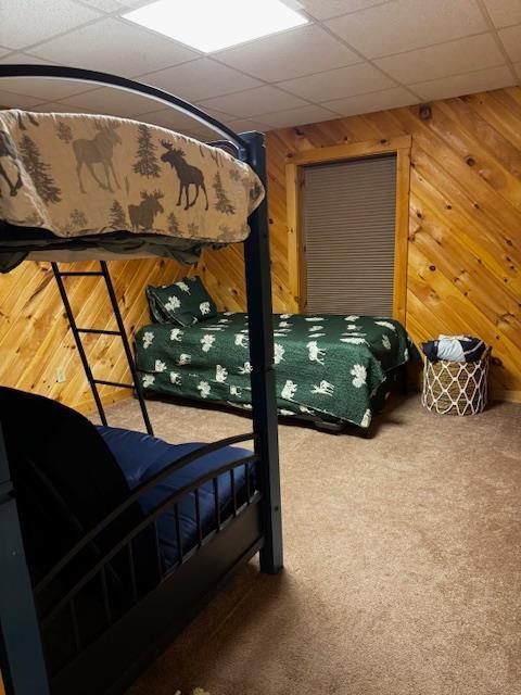 24 Cliffside Dr, Saint Albans, ME 04971 - carpeted bedroom with wood walls and a paneled ceiling