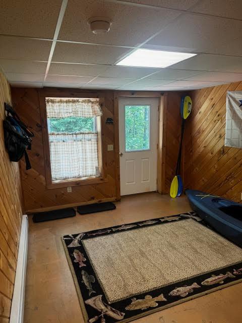 24 Cliffside Dr, Saint Albans, ME 04971 - doorway to outside featuring a baseboard radiator, wood walls, and a paneled ceiling