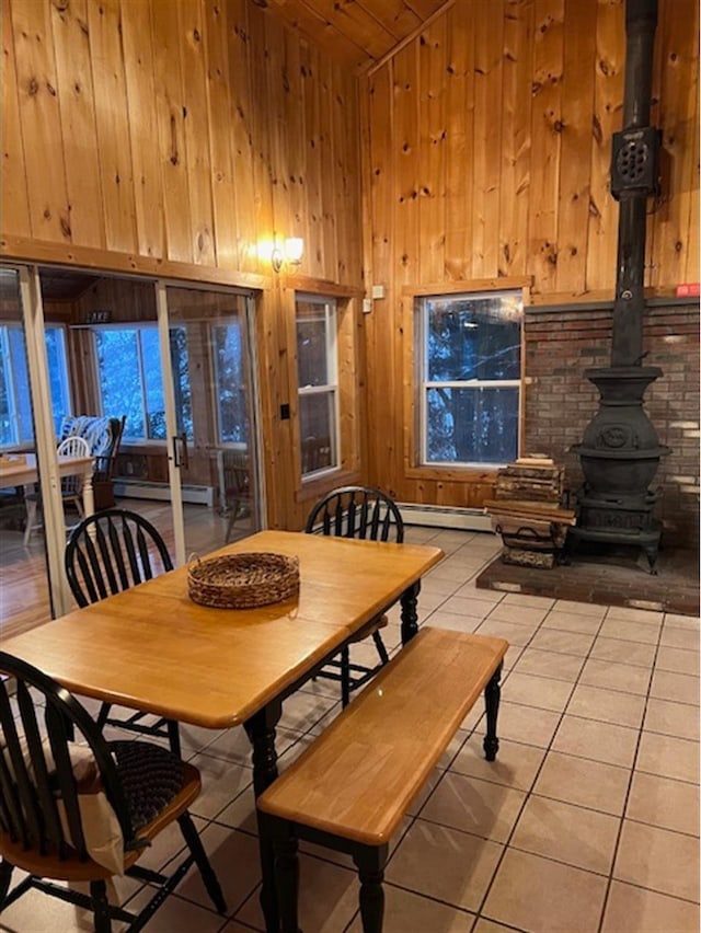 24 Cliffside Dr, Saint Albans, ME 04971 - dining space with light tile patterned floors, a wood stove, wood walls, lofted ceiling, and wood ceiling