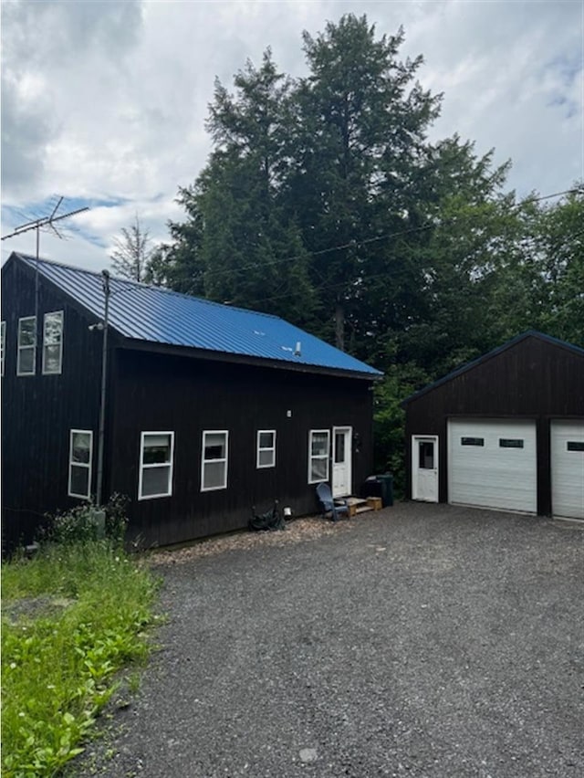 24 Cliffside Dr, Saint Albans, ME 04971 - view of side of home with a detached garage, a metal roof, and an outdoor structure