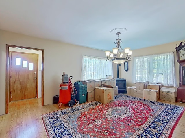 63 N Shore Dr, Owls Head, ME 04854 - dining area with a wood stove, healthy amount of natural light, light wood-type flooring, and a chandelier
