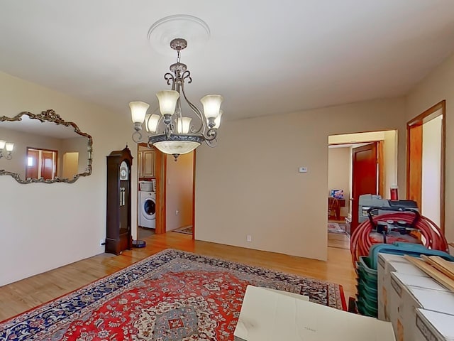 63 N Shore Dr, Owls Head, ME 04854 - dining space with light wood finished floors, washer / dryer, and a chandelier